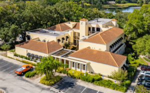 Aerial view of a serene wellness facility for clergy, featuring red tile roofs, lush landscaping, and tranquil surroundings for wellness retreats and restorative care."